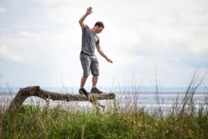 Practicing balance yoga outdoors on a scenic log.