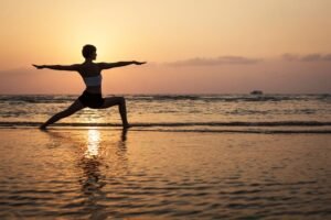 Yoga practice at sunset on the beach, embodying peace and balance.