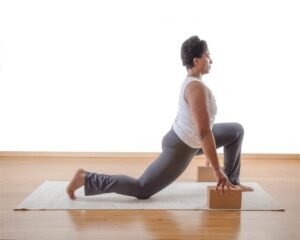 Yoga student practicing safe and autonomous poses with blocks for support.