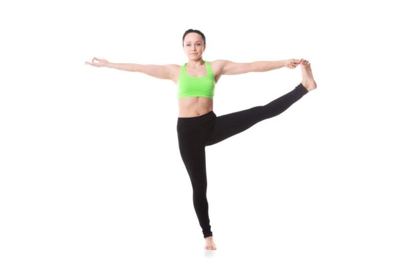 Fit woman practicing yoga in a vibrant green top and black leggings.