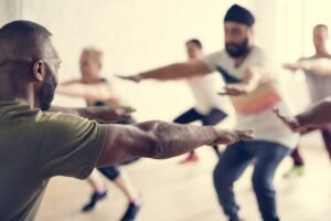 Group workout session with participants performing exercises in a studio environment.