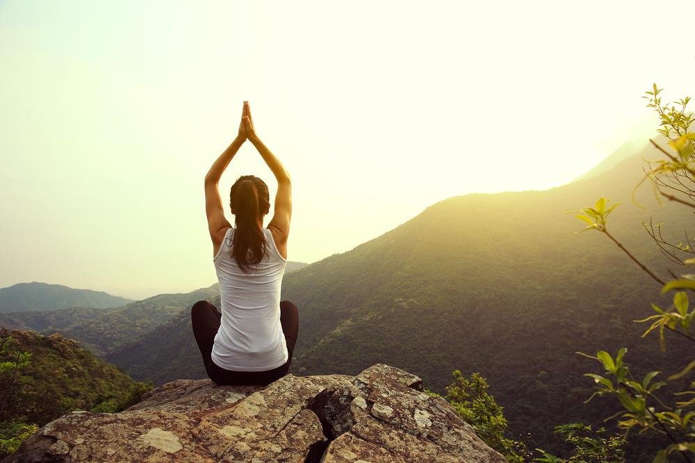 Sunset yoga meditation on a mountain for tranquility and mindfulness.