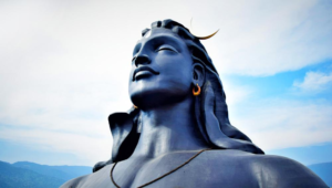 Statue of Shiva against a blue sky, showcasing stunning architecture and serene expression.