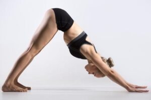 Woman practicing Downward Facing Dog yoga pose for flexibility and strength.
