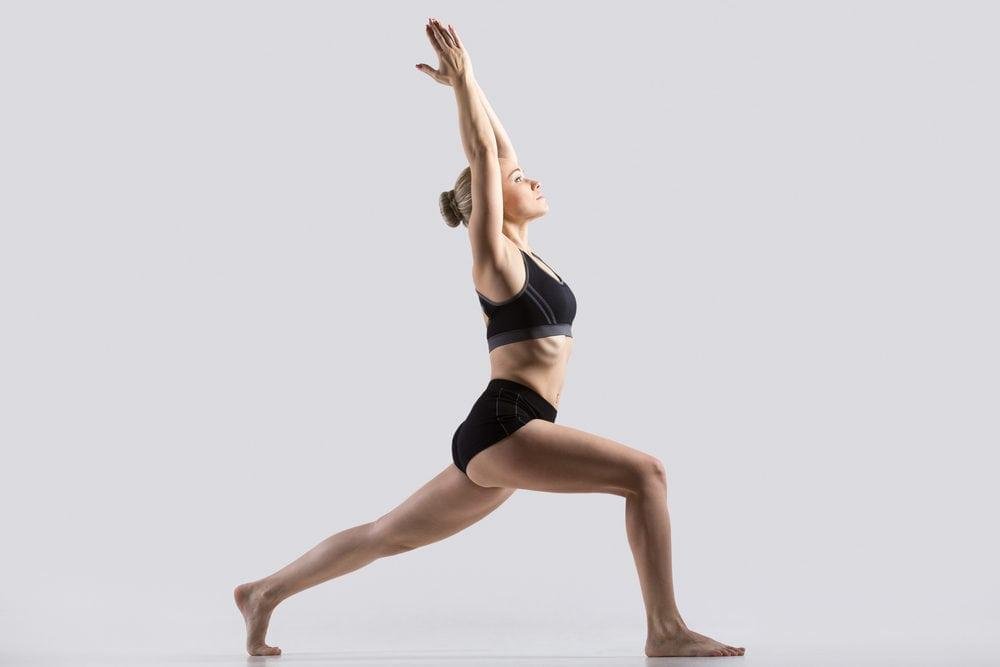 Woman practicing the Warrior yoga pose for flexibility and strength.