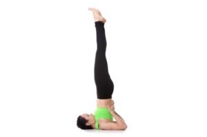 Woman performing the shoulder stand yoga pose for improved flexibility and strength.