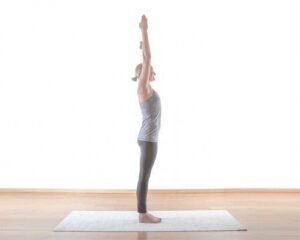 Woman performing yoga stretching pose on a mat.