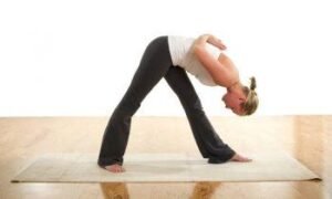 Woman practicing yoga stretching pose on mat for a healthy lifestyle.