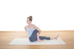 Woman practicing yoga stretch at home on a mat.