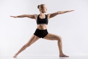 Woman practicing yoga in Warrior Pose, showcasing strength and balance.