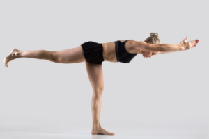 Woman performing a yoga balancing pose for flexibility and strength training.
