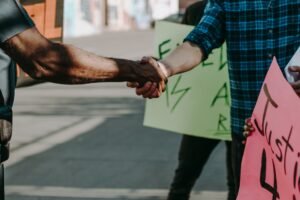 Handshake between two individuals at a protest for justice.