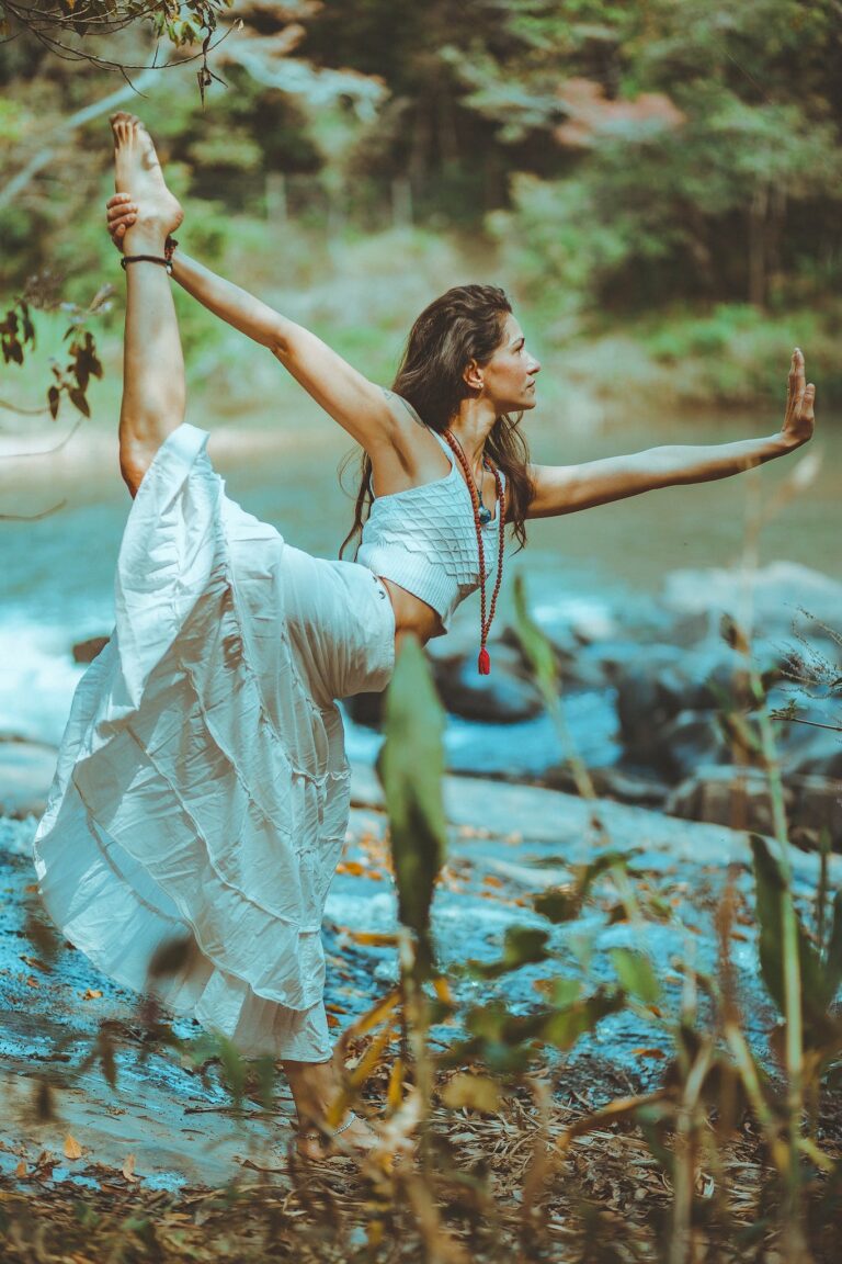 Graceful woman performing yoga in nature, embodying balance and tranquility.