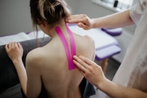 Kinesiology tape application for neck support during therapy session.