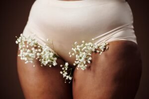 Woman in nude panties adorned with delicate babys breath flowers.