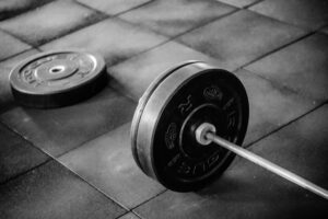 Black adjustable dumbbell on gym floor, perfect for strength training workouts.