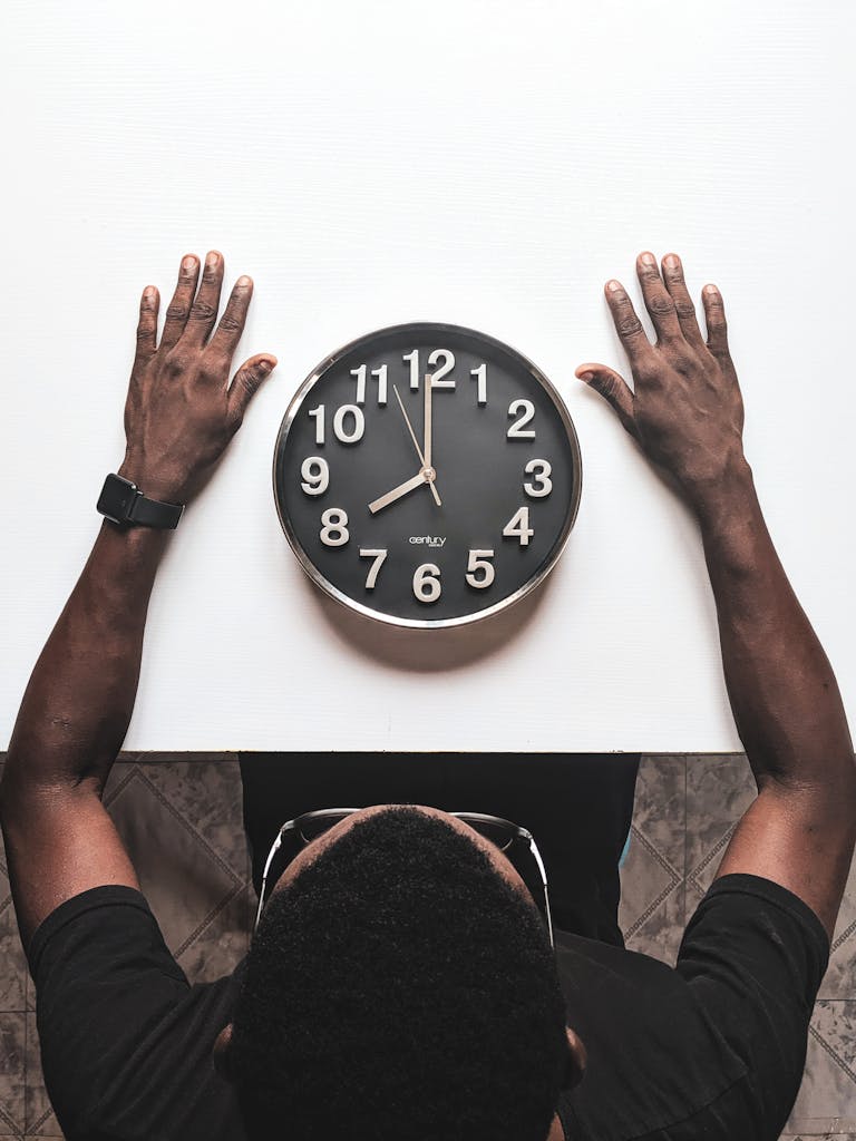 Top view of a black wall clock with hands positioned.