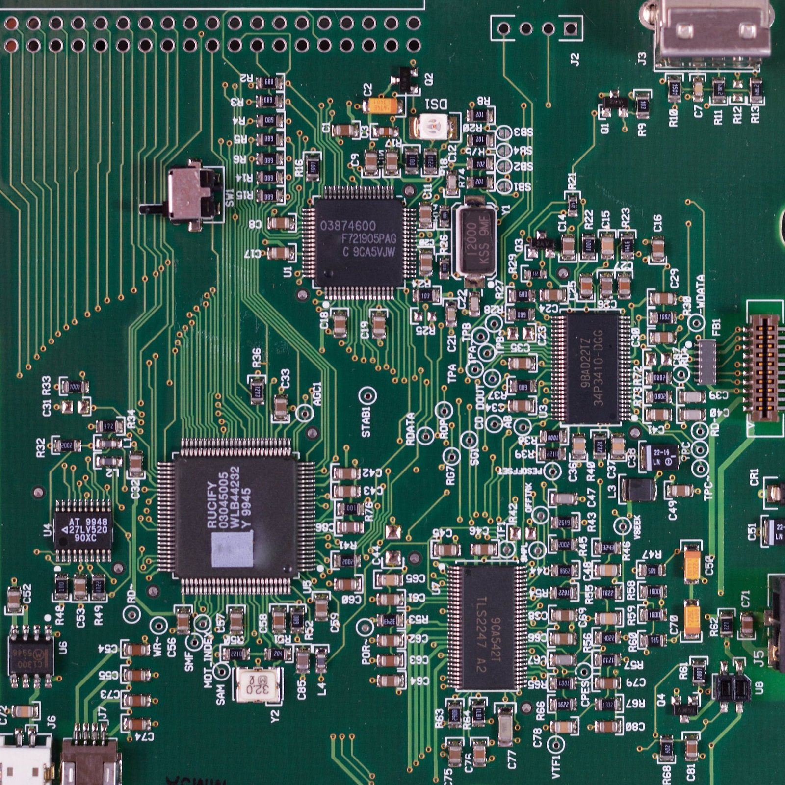 Detailed close-up of a green circuit board with electronic components.