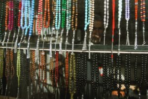 Vibrant beaded necklaces displayed at a colorful market stall.