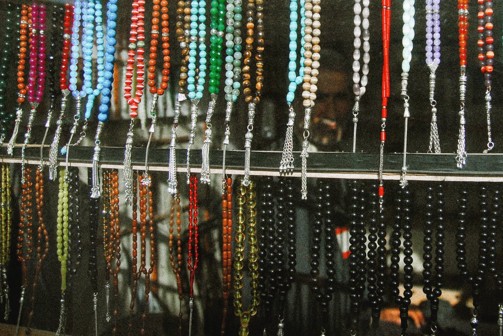 Vibrant beaded necklaces displayed at a colorful market stall.