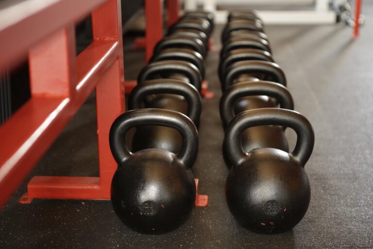 Row of black kettlebells in a gym setting.
