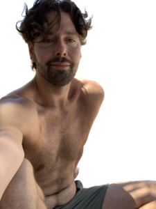 Shirtless man enjoying summer, capturing a relaxed moment outdoors.