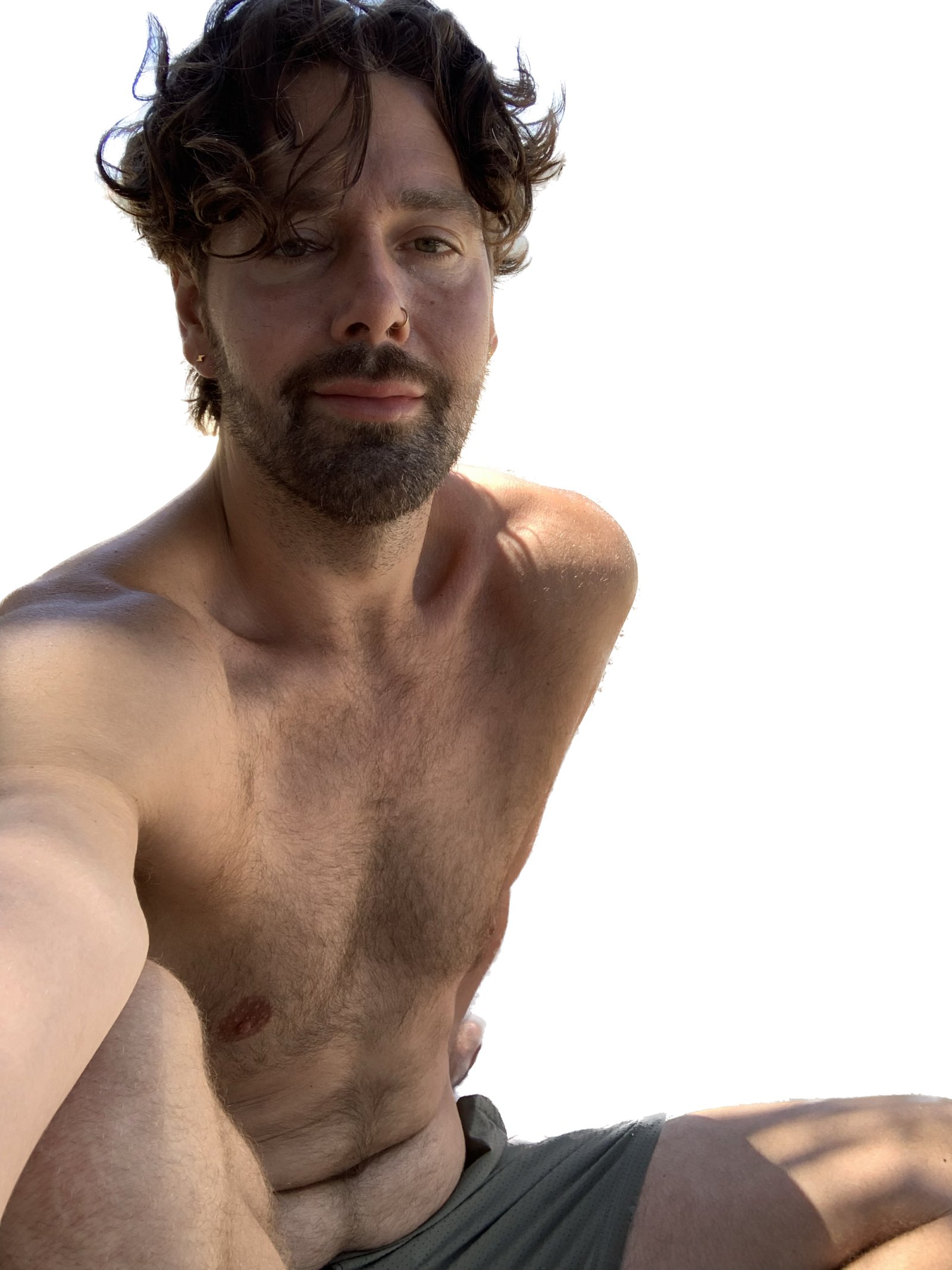 Shirtless man enjoying summer, capturing a relaxed moment outdoors.